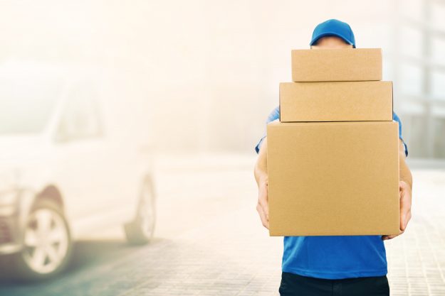 ABC Package Express Inc Inc. delivery man holding pile of cardboard boxes in front ABC Package Express Inc Inc. delivery man holding pile of cardboard boxes in front. copy space